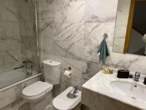 uma casa de banho branca com um WC e um lavatório em Hidden Gem Bed& Breakfast Estepona Hills em Estepona