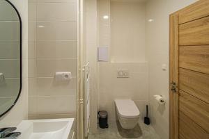 een witte badkamer met een toilet en een wastafel bij Old Town Rybna Apt by Ruterra in Praag