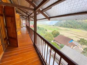 uma varanda de uma casa com vista para um campo em Duy Tuyen Ba Be Homestay Free BBQ em Bak Kan