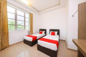 two beds in a room with a window at Nexus Hotel in Melaka