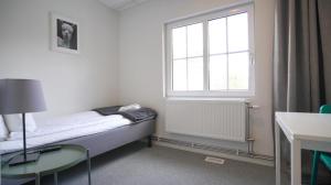 een kleine kamer met een bed en een raam bij Forenom Hostel Gothenburg Säve in Göteborg