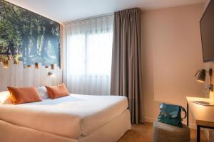 um quarto de hotel com uma cama e uma janela em The Originals City, Hôtel Alteora, Poitiers Site du Futuroscope (Inter-Hotel) em Chasseneuil-du-Poitou
