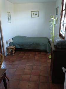 een slaapkamer met een groen bed en een tegelvloer bij Malarias 1 in Rochemaure