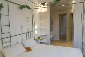 1 dormitorio con cama blanca y espejo en La Casa Di Iulia, en Roma
