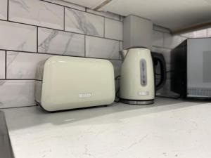 a toaster sitting on a counter next to a wall at The Coach House @ Barry MGroupSA in Barry