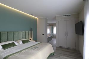 sypialnia z dużym łóżkiem i telewizorem z płaskim ekranem w obiekcie Relais Le Betulle w mieście Conegliano