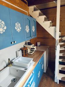 a kitchen with blue cabinets and a sink at Casutele Suhardul Mic in Lacu Rosu