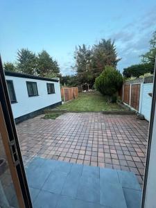 an open door to a backyard with a brick driveway at House in London near O2, Greenwich & Canary Wharf in Eltham