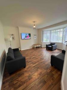a living room with two couches and a flat screen tv at House in London near O2, Greenwich & Canary Wharf in Eltham