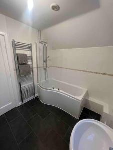 a bathroom with a tub and a toilet and a sink at House in London near O2, Greenwich & Canary Wharf in Eltham