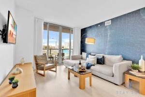 a living room with a couch and a table at Modern Condo - Amazing Pool - Gym - Balcony in Hallandale Beach