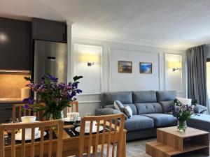 un soggiorno con un divano blu e un tavolo di Apartamento Amarillo Oceanview a Playa Fañabe