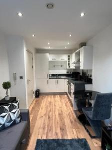 a kitchen with white cabinets and a wooden floor at cosy and prime location in Sheffield