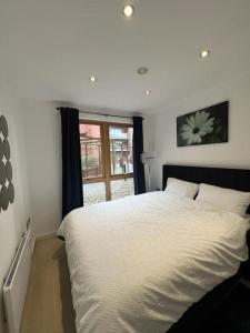 um quarto com uma cama branca e uma janela em cosy and prime location em Sheffield