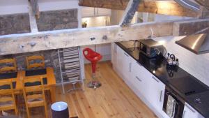 an overhead view of a kitchen with a red stool at Sunny Corner - Bright, Spacious Apartment with Harbour Views - 102 in Penzance