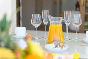 een tafel met wijnglazen en een kan sinaasappelsap bij Valle Marina Apartamentos in Mogán