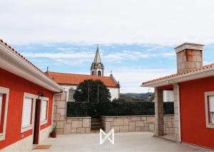 a view of a church from between two buildings at MyStay - Oliveira Douro House in Peso da Régua