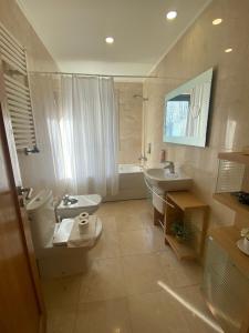 uma casa de banho com um WC, um lavatório e uma banheira em Bom dia Parque Nações LisboaZ em Lisboa