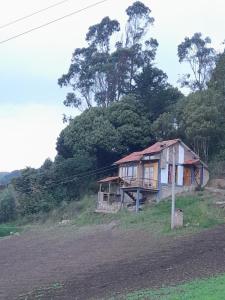 una casa al lado de una colina en Cabaña Mirador, las Acacias de Teli en Ventaquemada