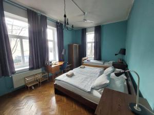 - une chambre avec un lit, un bureau et des fenêtres dans l'établissement VV ART, unique Vila in Ljubljana city center, à Ljubljana