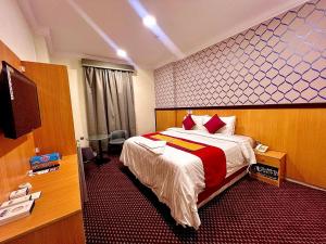 a hotel room with a bed and a flat screen tv at فندق رفاق Refaq Hotel in Makkah