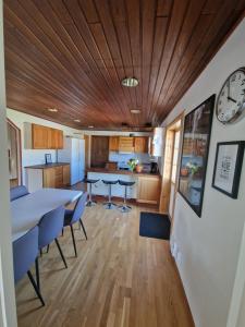 a kitchen with a table and chairs and a clock on a wall at Annas Ställe B&B in Byxelkrok +33 photos