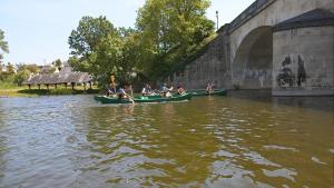 a group of people in a boat on the water near a bridge at Le petit nid de Muzy in Muzy +4 photos