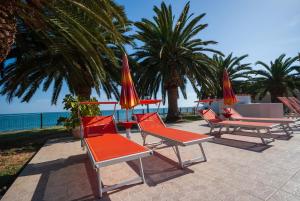 un grupo de sillas con sombrillas en la playa en Villa Lucia, en Mattinata