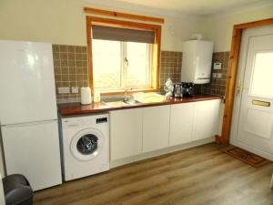 a kitchen with a sink and a washing machine at Annexe Meadowbank Dumfries in Dumfries