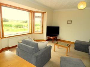 a living room with a couch and a tv at Annexe Meadowbank Dumfries in Dumfries