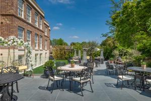 a patio with tables and chairs in front of a building at Harbour Hotel & Spa Richmond in Richmond upon Thames