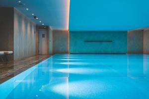 a swimming pool in a room with blue lighting at Harbour Hotel & Spa Richmond in Richmond upon Thames