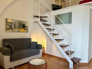 een woonkamer met een trap en een bank bij Sperlonga Paradise Central Loft in Sperlonga