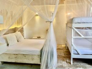 帕洛米諾的住宿－Casa Kai，一间卧室配有两张双层床和蚊帐