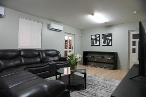a living room with a black leather couch and a fireplace at City Lights 143 in Tumon