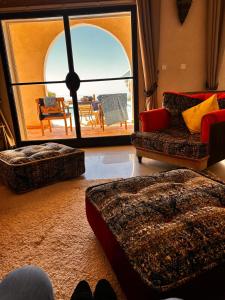 een woonkamer met 2 banken en een groot raam bij Villa vue mer et campagne in Essaouira