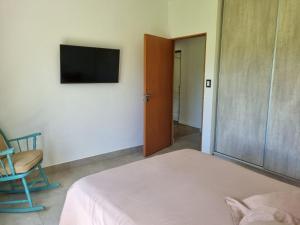 a bedroom with a bed and a television on a wall at Santas Hogar in Santa Ana