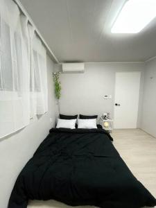 um quarto com uma grande cama preta num quarto em Stay Songpa em Seul