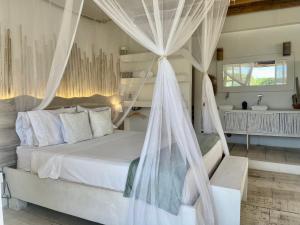 1 dormitorio con cama blanca y mosquiteras en Casa Kai en Palomino