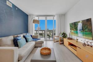 a living room with a couch and a tv at Amazing Pool - Balcony - Gym - Near Beach in Hallandale Beach
