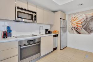 a kitchen with a sink and a microwave at Amazing Pool - Balcony - Gym - Near Beach in Hallandale Beach