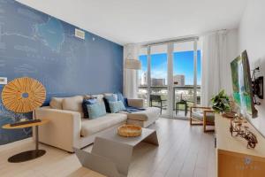 a living room with a couch and a blue wall at Amazing Pool - Balcony - Gym - Near Beach in Hallandale Beach +39 photos