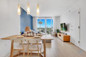 a dining room and living room with a table and chairs at Amazing Pool - Balcony - Gym - Near Beach in Hallandale Beach
