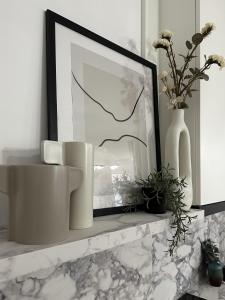 a shelf with vases and a picture and flowers at D26 Luxury Suites in Budapest