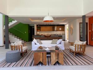 Casa de Praia em Interlagos - 4 suítes a poucos metros do mar في كامساري: غرفة معيشة مع أريكة وطاولة