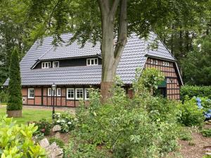 una casa con techo negro y jardín en Ferienhaus Familie Martens, en Sittensen