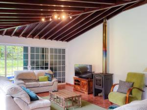 a living room with a couch and a tv at Casa Tia Néné - Green Glassyard in Lagoa