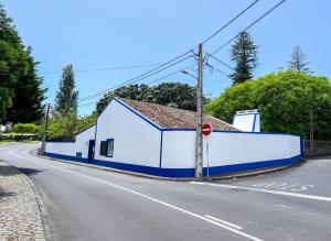 un edificio bianco e blu sul ciglio di una strada di WelcomeBuddy - Casa Tia Néné - Green Glassyard a Lagoa