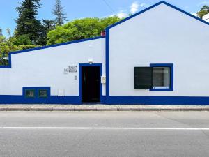 un edificio azul y blanco con puerta en WelcomeBuddy - Casa Tia Néné - Green Glassyard, en Lagoa