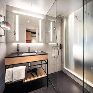 La salle de bains est pourvue d'un lavabo et d'une douche. dans l'établissement IntercityHotel Paderborn, à Paderborn